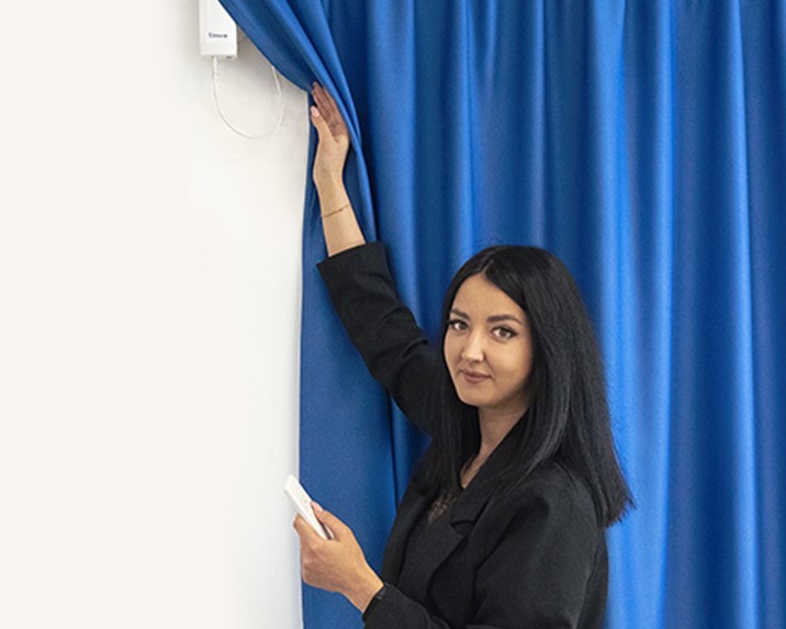 Девушка управляет электрокарнизом с помощью пульта